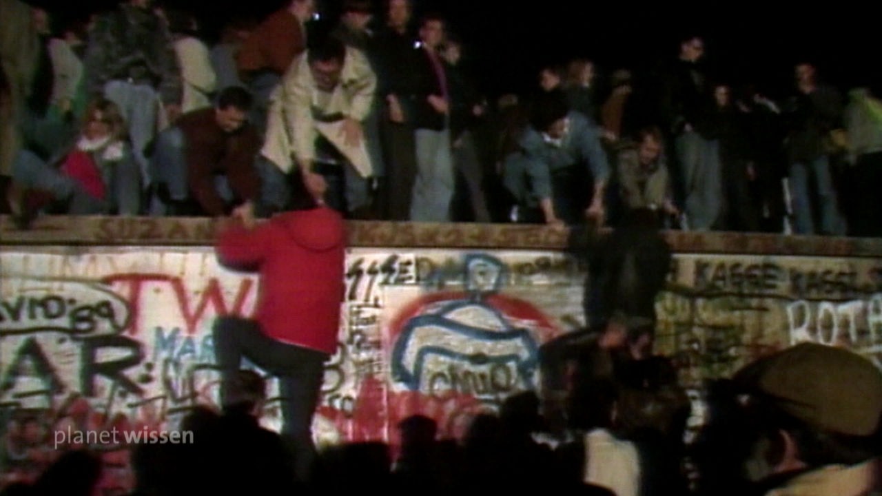 Menschenmenge an und auf der Berliner Mauer