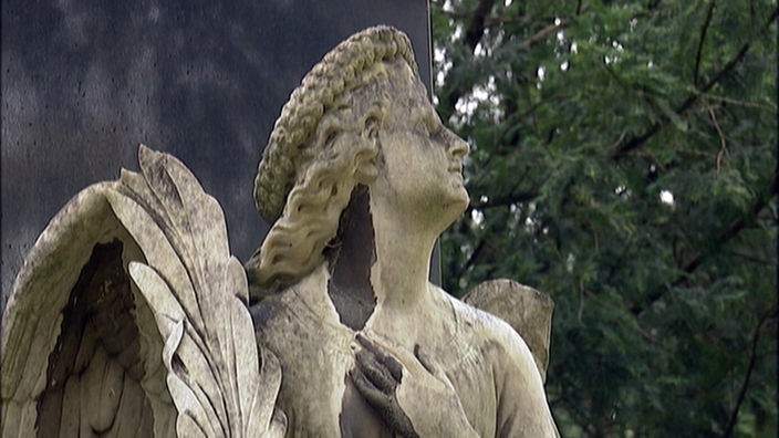 Engelsstatue aus Stein auf einem Friedhof.