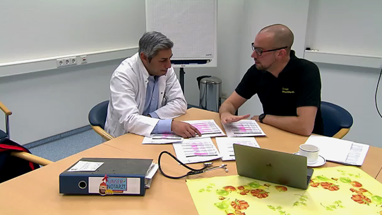 Dr. Martin Schiffarth sitzt mit einem anderen Arzt an einem Besprechungstisch.