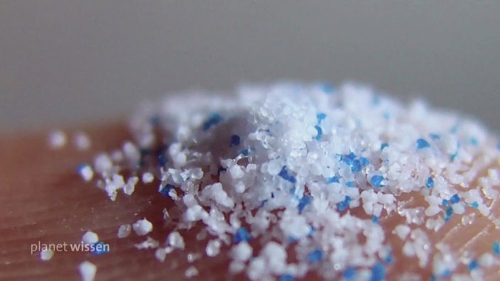 Ansammlung weißer und blauer Teilchen von Mikroplastik