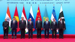 Die Staatsoberhäupter der Mitglieder der „Shanghaier Organisation für Zusammenarbeit“ (SOZ), stehen vor einer Wand mit ihren jeweiligen Nationalflaggen hinter sich.