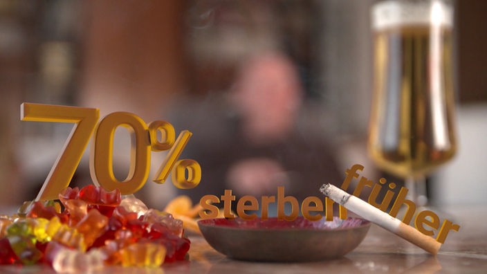 Auf einem Tisch liegen Gummibärchen, daneben ein Aschenbecher mit brennender Zigarette. Eingeblendet ist '70 Prozent streben früher'.