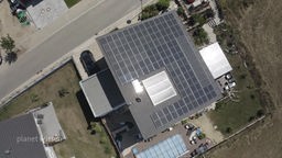 Luftaufnahme: Blick auf ein Einfamilienhaus mit einer großen Solaranlage auf dem Dach.