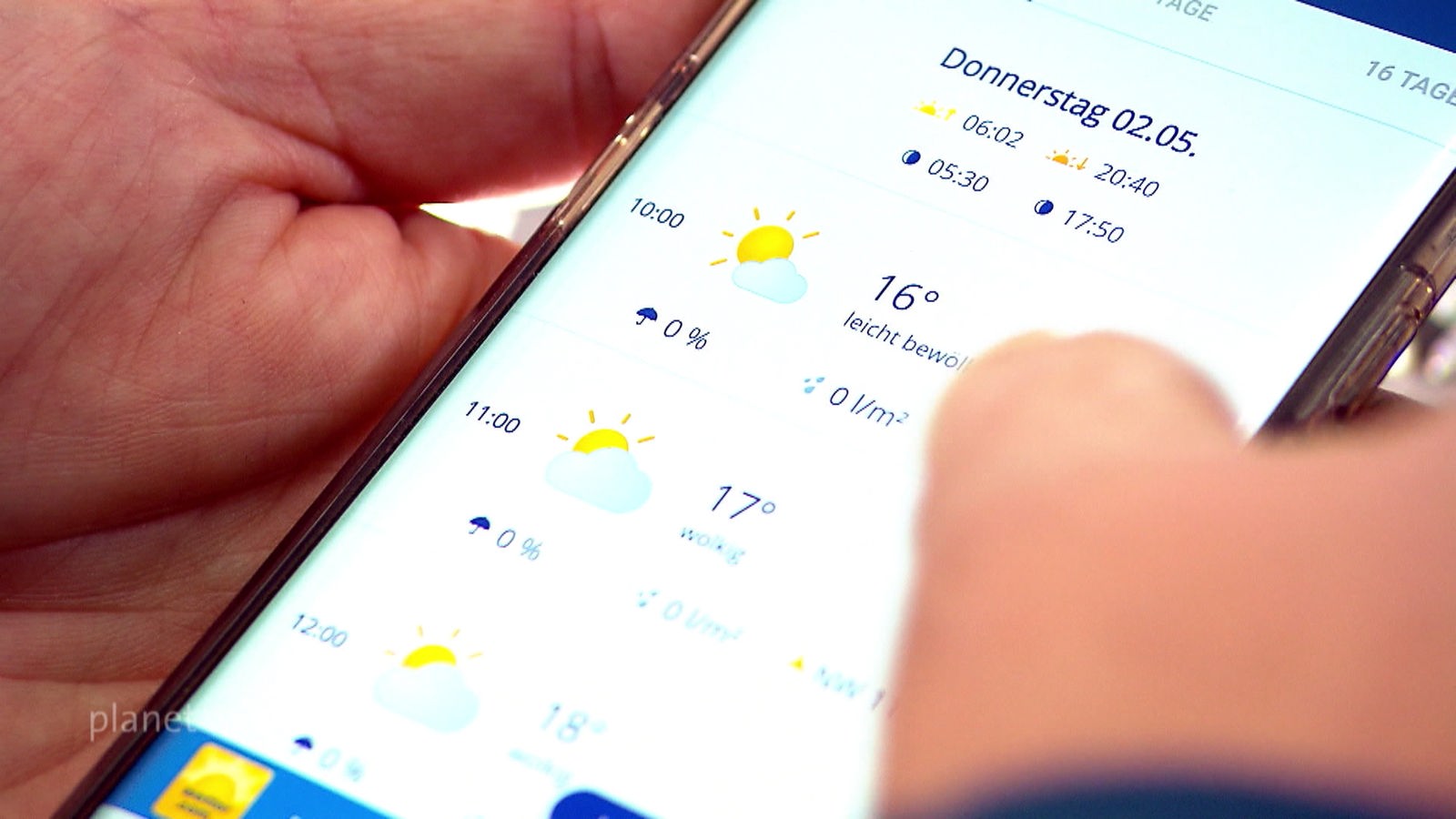 Zwei Hände halten ein Smartphone, auf dem eine Wetter-App geöffnet ist.
