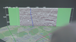 Grafik: Über einer Geländekarte ist ein seismisches Bild des Untergrundes zu sehen.