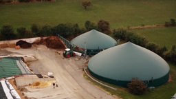 Luftaufnahme: Blick auf zwei große runde Biogasbehälter auf einem landwirtschaftlichem Betrieb.