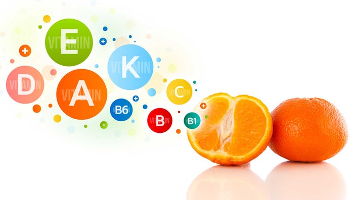 Grafik: Zwei Orangenhälften und bunte Vitamin-Symbole. 