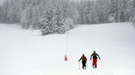 Skifahrer laufen Piste hoch