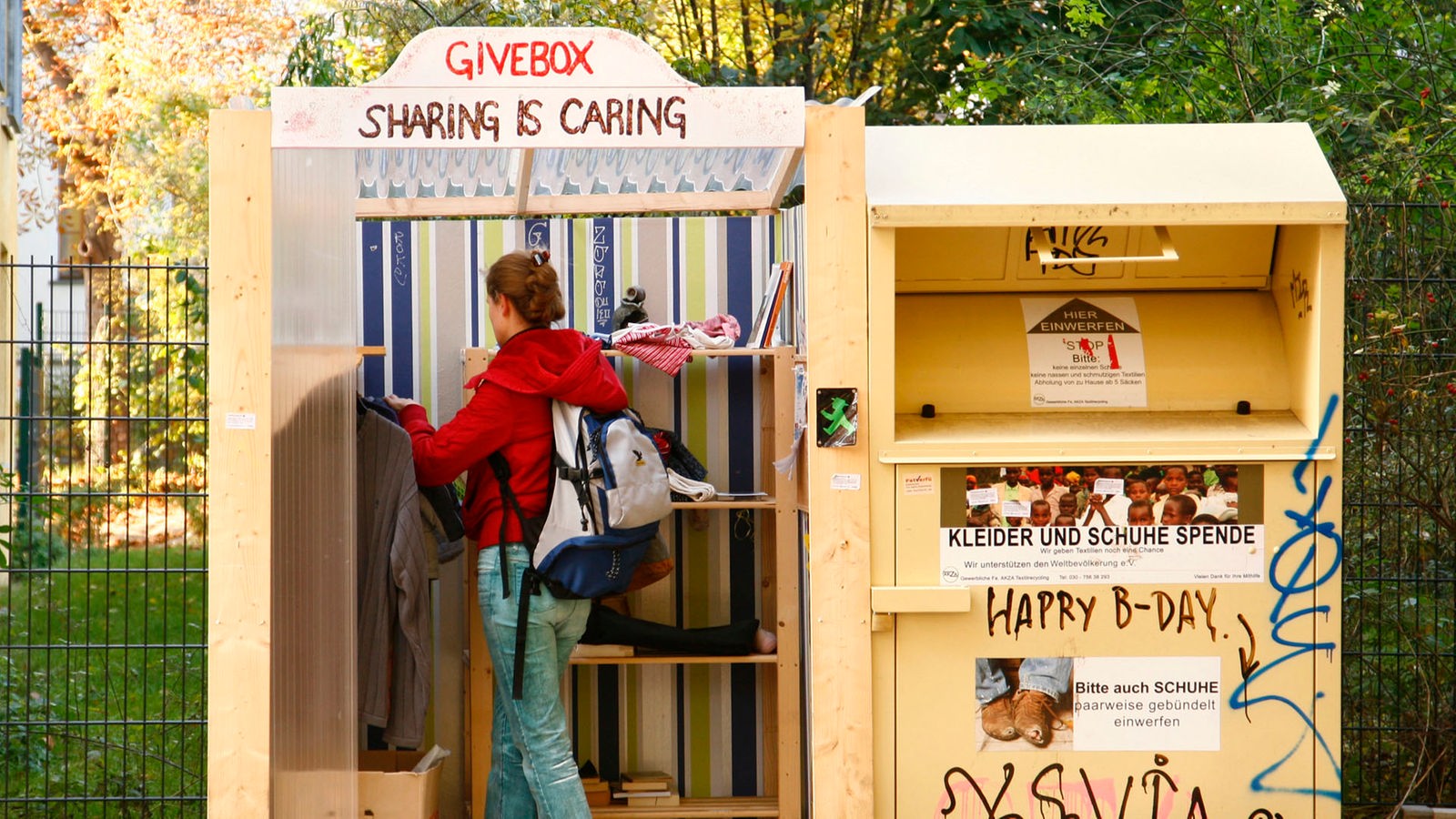 Eine Frau prüft das Angebot in einer sogenannten "Givebox".