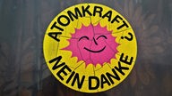 Das Logo der Anti-Atomkraft-Bewegung: Eine lachende rote Sonne auf gelbem Kreis mit der Aufschrift 'Atomkraft - Nein danke'.