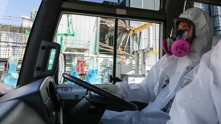 Ein Fahrer im Schutzanzug fährt durch das verwüstete Kernkraftwerk Fukushima