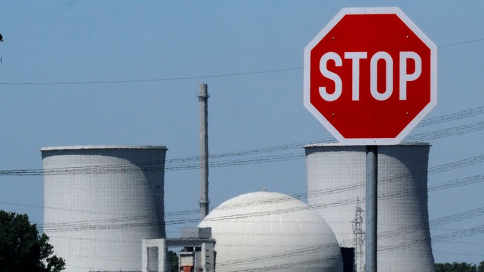 Ein Stoppschild, im Hintergrund das Kernkraftwerk Biblis in Hessen