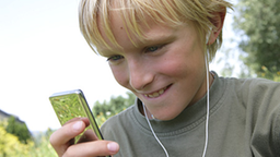 Ein Junge schaut auf sein tragbares Abspielgerät