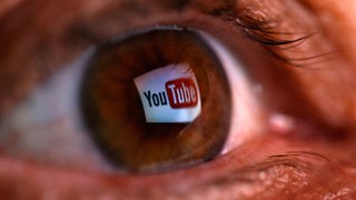 Das Logo YouTubes spiegelt sich im Auge eines Betrachters