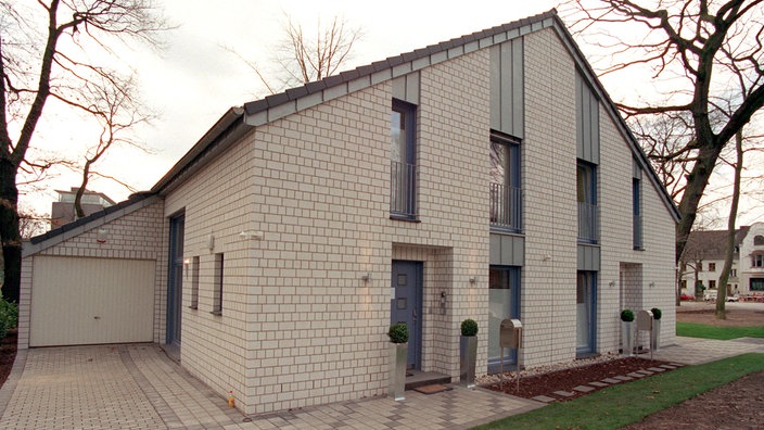 Ein graues Doppelhaus mit Garage. | Bildquelle: dpa/Jörg Carstensen Ein graues Doppelhaus mit Garage.