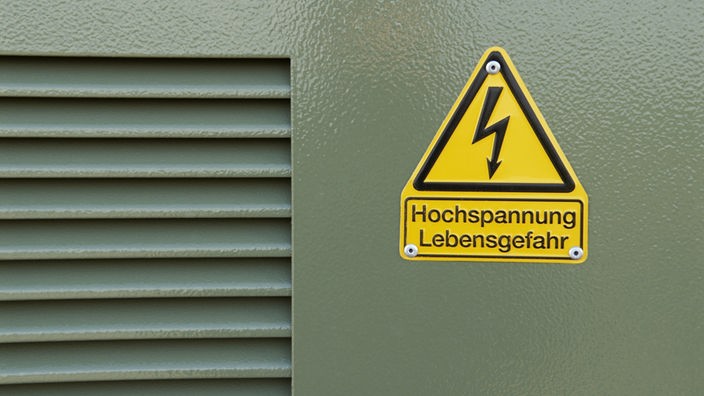 Front einer Trafostation: Graue Blechtür mit gelben Schild 'Hochspannung Lebensgefahr'