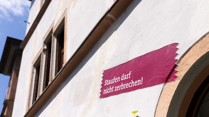Staufen im Breisgau: Ein Aufkleber mit der Aufschrift "Staufen darf nicht zerbrechen!" klebt auf dem Rathaus der Stadt