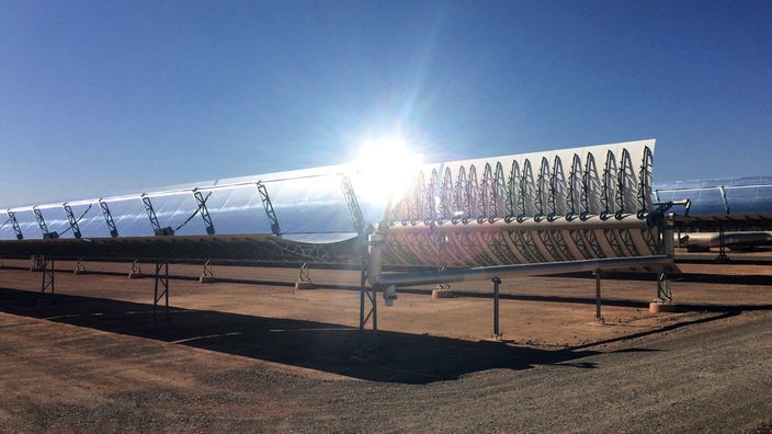 Parabolspiegel in einem Solarkraftwerk in der Wüste bei blauem Himmel