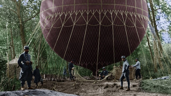 Schwarzweiß-Foto eines großen Ballons, neben dem mehrere Männer stehen