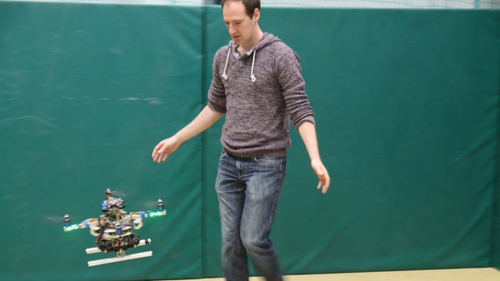 Der Forscher Paul Benz scheucht einen autonom fliegenden Quadrokopter von sich weg 