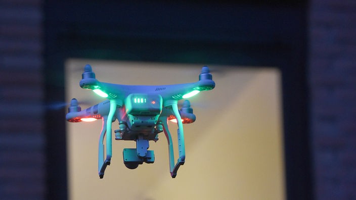 Drohne schwebt vor Fenster eines Wohnhauses