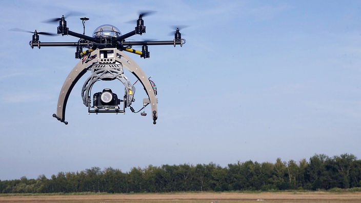 Drohne mit Kamera über einem Feld