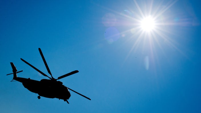 Hubschrauber bei strahlendem Sonnenschein vor blauem Himmel