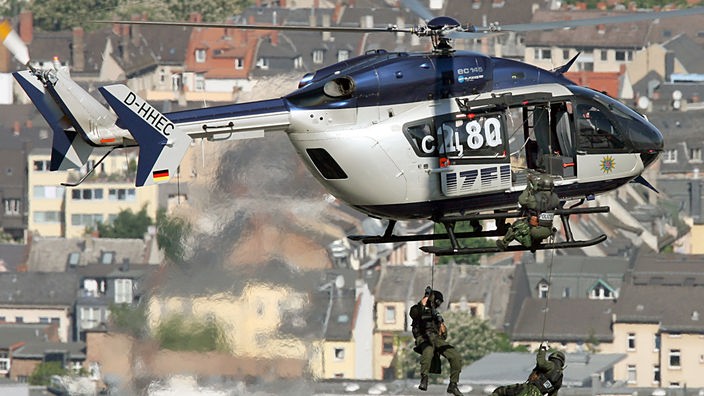 Polizisten seilen sich von einem Hubschrauber ab