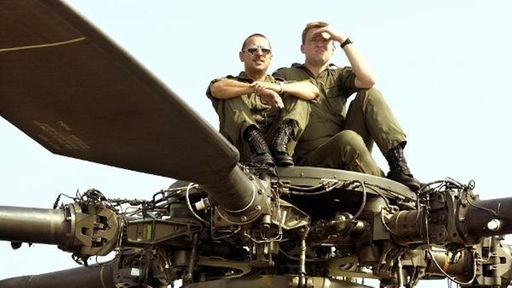 Zwei Soldaten sitzen auf dem Rotor eines Hubschraubers