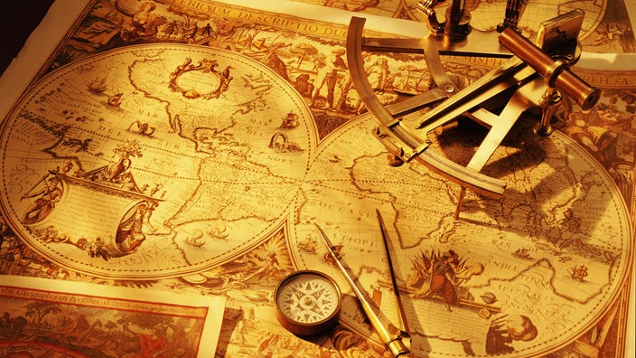  Sextant, Zirkel und Kompass liegen auf einer alten Weltkarte