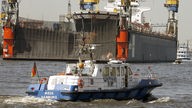 Beamte der Wasserschutzpolizei fahren im Hamburger Hafen auf ihrem Wasserschutzboot Streife