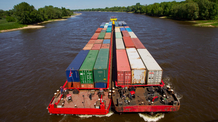 Container werden mit einem Schubverband auf der Elbe in Magdeburg transportiert