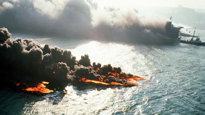 Brennender Tanker auf dem Wasser. Schwarze Rauchwolken steigen von der Wasseroberfläche auf