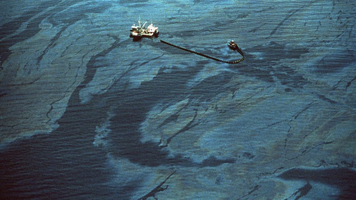 Luftbild: Ölspuren im Meer. Im Zentrum des Bildes ist eine schwimmende Barriere zu sehen