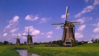 Drei Windmühlen an einem Kanal in Holland