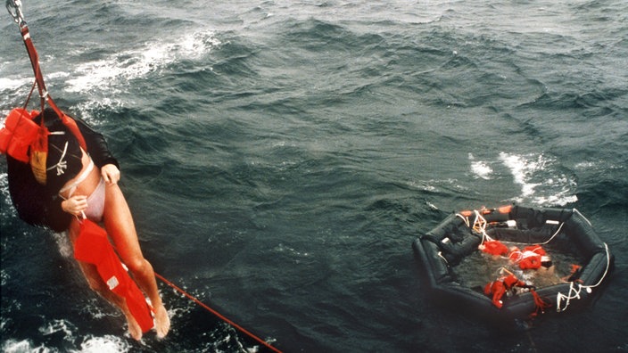 Nach dem Fährunglück der "Estonia" werden Überlebende von einer Rettungsinsel in einen Hubschrauber gezogen. | Bildquelle: dpa Picture-Alliance / Pressensb Nach dem Fährunglück der "Estonia" werden Überlebende von einer Rettungsinsel in einen Hubschrauber gezogen.
