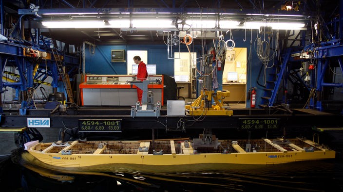 Ein Modellschiff aus Holz wird in der Hamburgischen Schiffbau-Versuchsanstalt getestet