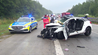 Unfall auf der Autobahn mit Polizei und demoliertem Auto.