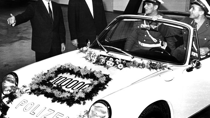 Ein geschmückter Polizei-Porsche 912 Targa mit zwei Polizisten
