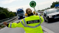 Eine Polizistin winkt einen Lastwagen von der Autobahn