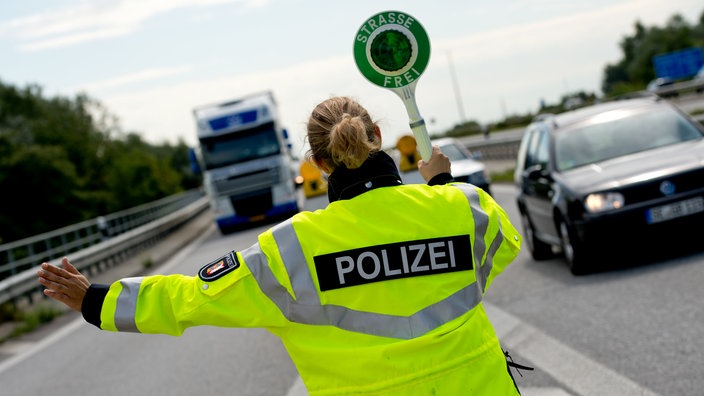 Eine Polizistin winkt einen Lastwagen von der Autobahn | Bildquelle: dpa/Sven Hoppe Eine Polizistin winkt einen Lastwagen von der Autobahn