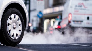 Auto mit Abgasen, die aus dem Auspuff kommen, auf der Corneliusstraße in Düsseldorf
