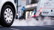 Auto mit Abgasen, die aus dem Auspuff kommen, auf der Corneliusstraße in Düsseldorf