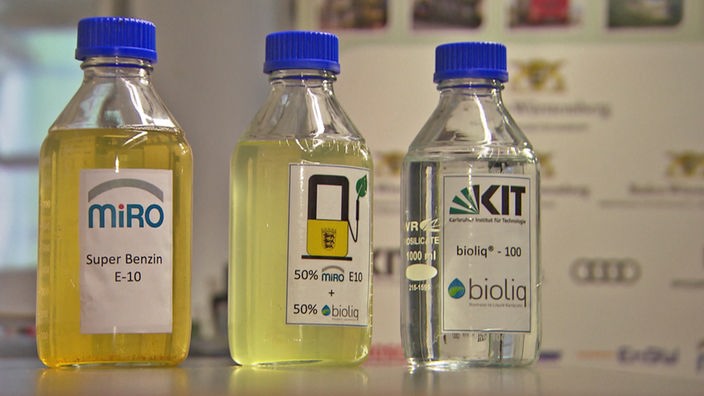 synthetischer, klarer Kraftstoff wird aus einer Karaffe ausgegossen oder 1-Liter-Flasche mit synthetischem Kraftstoff mit Label 