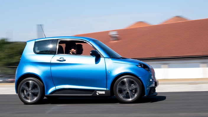 Ein blaues Elektroauto fährt auf einer Straße | Bildquelle: WDR/dpa/Marius Becker Ein blaues Elektroauto fährt auf einer Straße