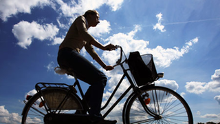  Radfahrerin vor blauem Himmel