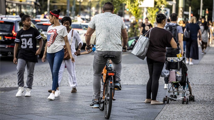 Radfahrer fährt auf einem Gehweg zwischen Passanten | Bildquelle: Imago Radfahrer fährt auf einem Gehweg zwischen Passanten
