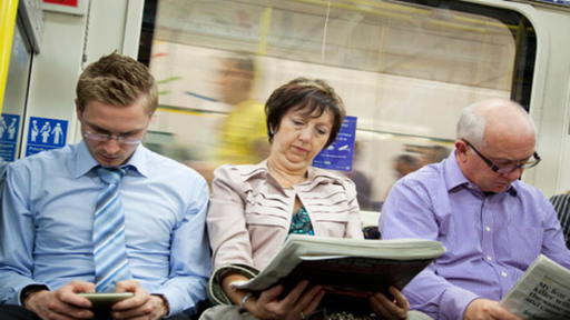 Drei lesende Menschen in einem Zug
