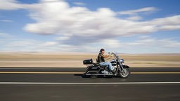  Motorradfahrer auf einer Straße in der Wüste