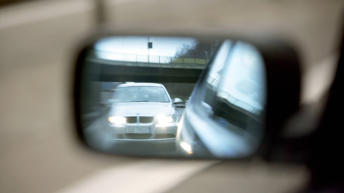 Blick in Rückspiegel auf der Autobahn. Ein Auto fährt auf wenige Meter auf | Bildquelle: Imago/Jochen Tack Blick in Rückspiegel auf der Autobahn. Ein Auto fährt auf wenige Meter auf